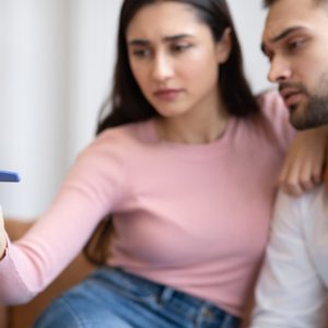 A woman and man read an at-home pregnancy test